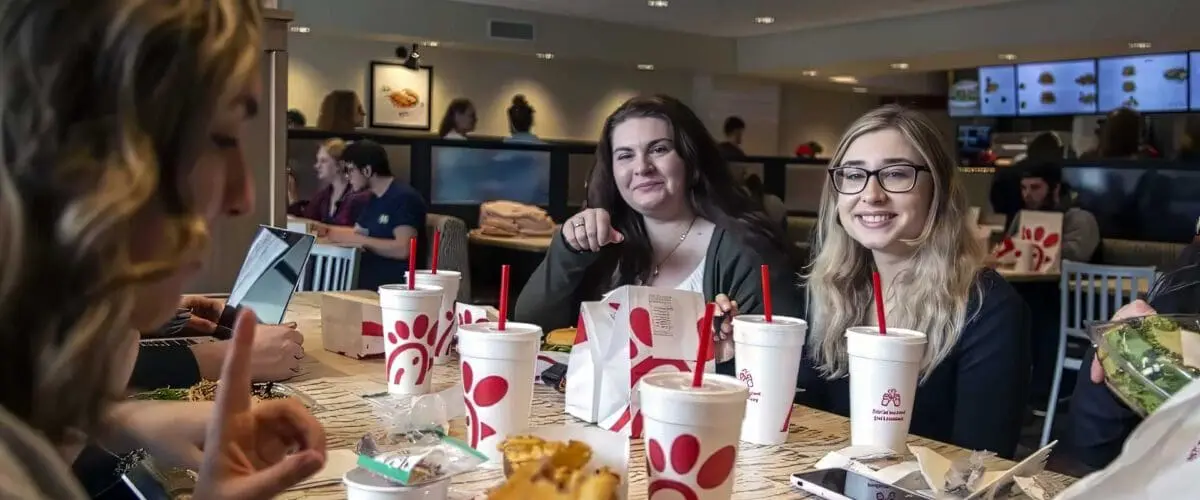 Students eating and enjoying conversation inside of Chick-fil-A