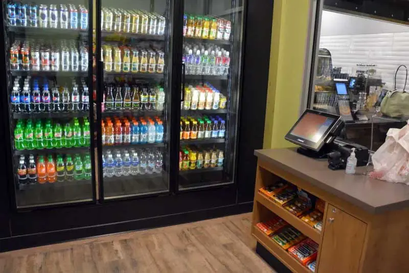View of beverage cooler and self checkout stand in market