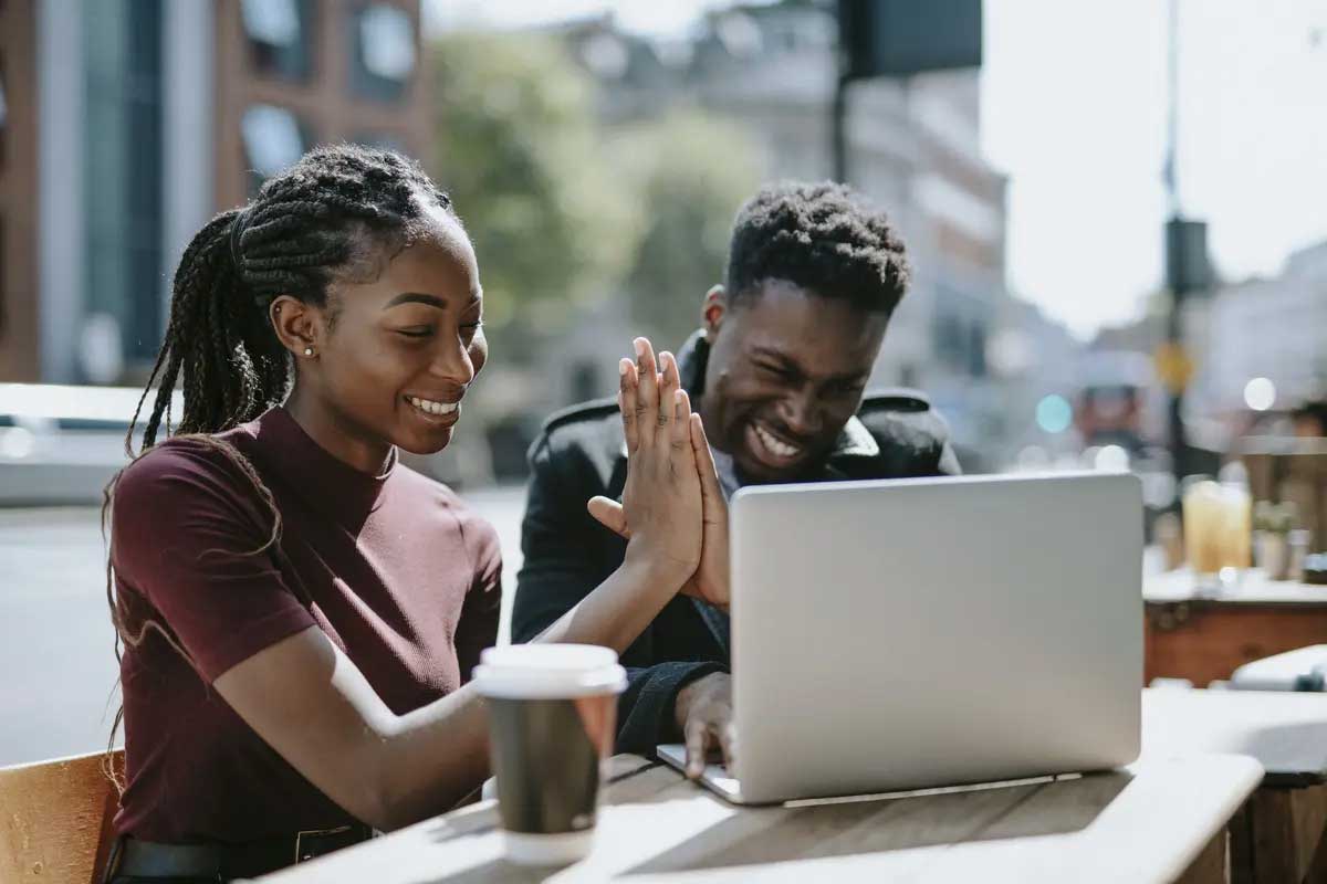 Two students working on laptop and drinking coffee